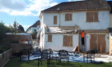 Casa unifamiliar protegida con plásticos antes de pintar la fachada Casa unifamiliar protegida con plásticos antes de pintar la fachada